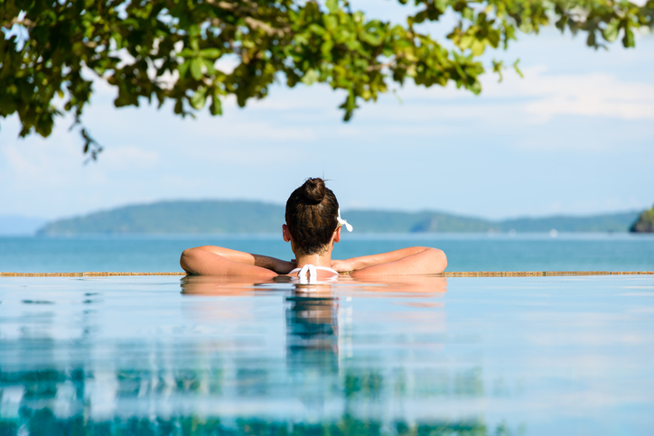 Relax and spa concept. Woman with a flower in hair relaxing in a pool at Krabi, Thailand.